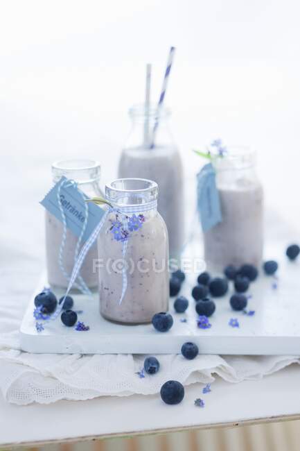 Blueberry milkshakes in glass bottles — Stock Photo