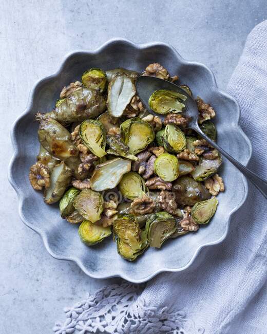 Fried brussels sprouts and Jerusalem artichokes with walnuts — Stock Photo