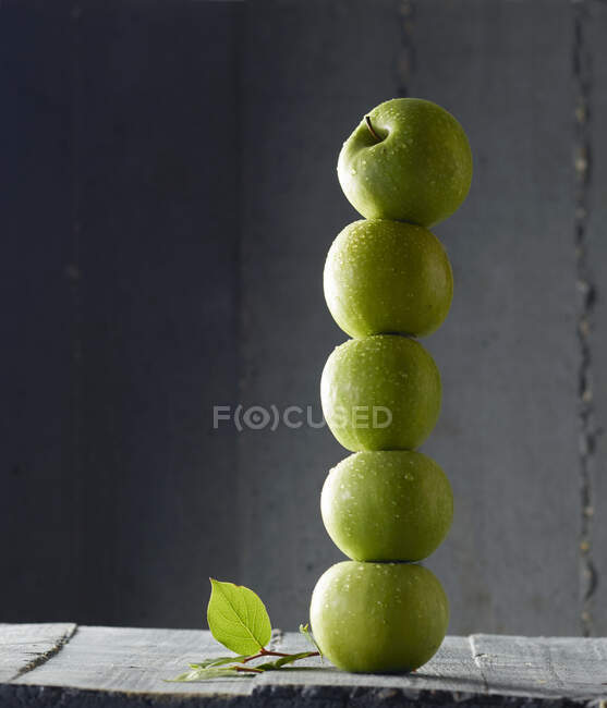 Manzanas verdes apiladas en una torre - foto de stock