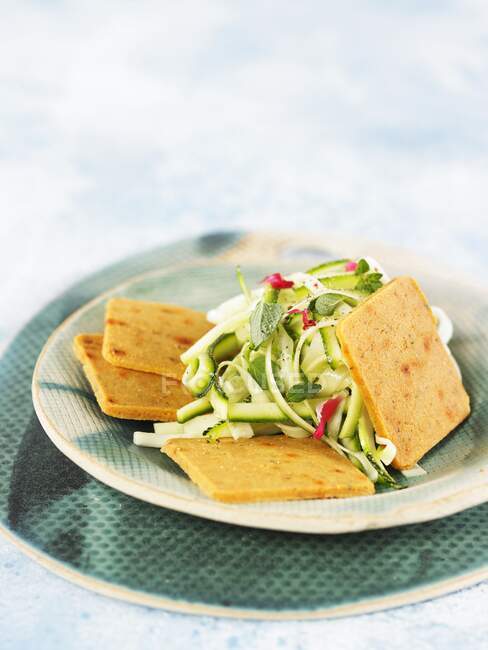Spicy macadamia cheese crackers with courgettes salad — Stock Photo