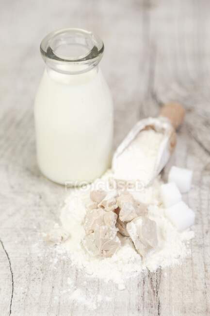 Milk, flour, sugar and crumbled yeast — Stock Photo