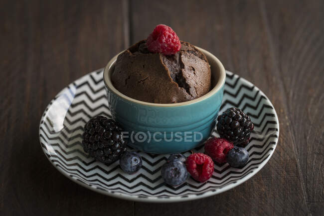 Chocolate cake with a liquid core garnished with berries — Stock Photo