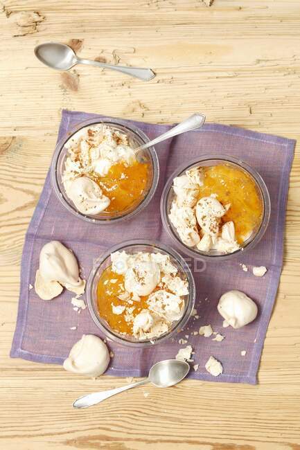 Bowls of Yogurt and apricot jam desserts with meringues — Stock Photo