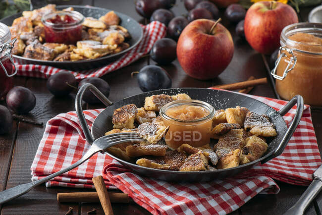 Crunchy desserts with applesauce and roast plums in pans — Stock Photo