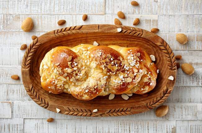 A yeast plait with nib sugar and almond flakes — Stock Photo