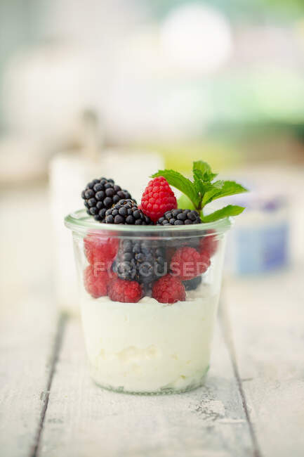 Cottage cheese with fresh raspberries and blackberries and mint in glass — Stock Photo