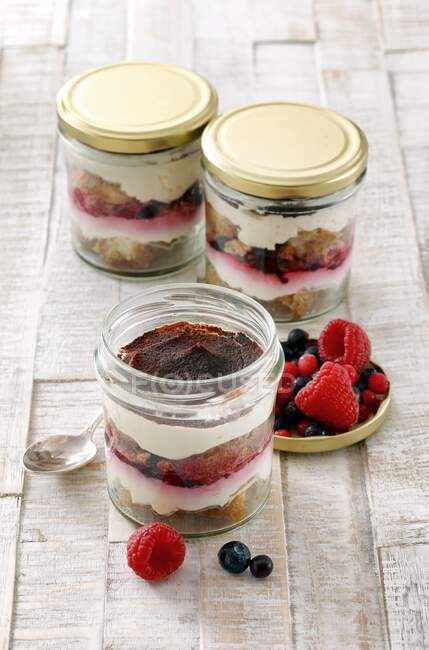 Tiramisu with fresh berries in glass jars — Stock Photo