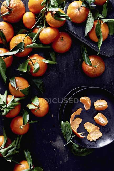 Mandarinen mit Blättern, ganz und geschält — Stockfoto