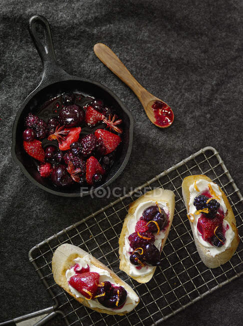 Baguette slices topped with cream cheese and mixed berries — Stock Photo