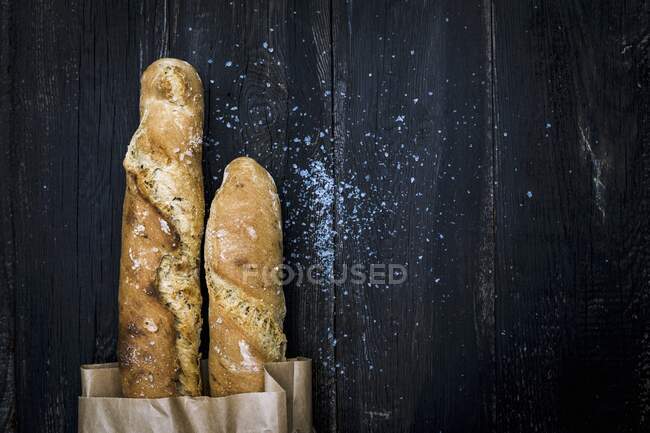 Homemade malt baguettes in a paper bag — Stock Photo