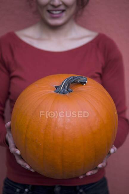 A woman holding a giant pumpkin — Stock Photo