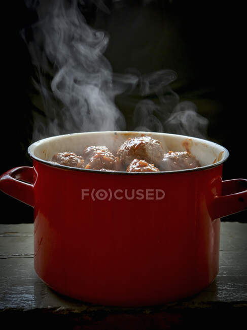 Boulettes de viande fumantes dans une casserole rouge — Photo de stock