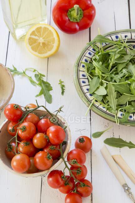 Cohete, tomates, pimientos, limón y aceite - foto de stock