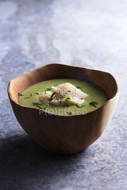 Pea soup with cod in a wooden bowl — Stock Photo