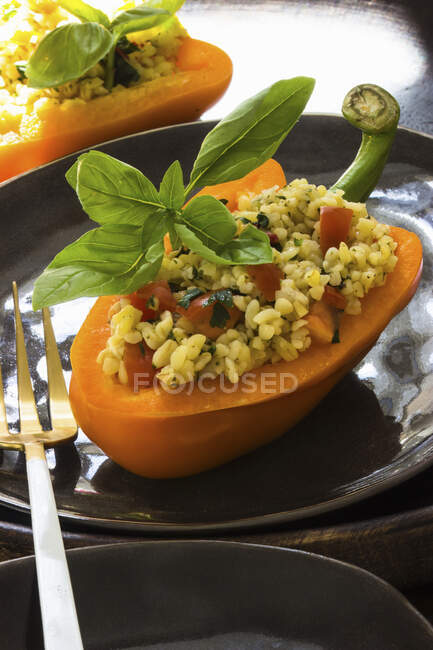 Salada Bulgur com tomate e ervas servidas na metade pimenta — Fotografia de Stock