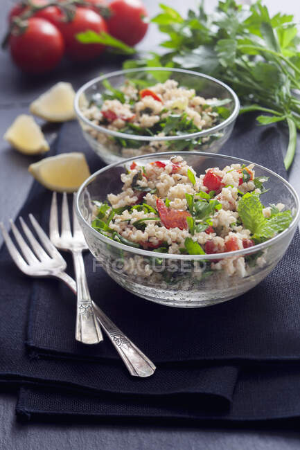 Tabouli-Salat mit Minze, Petersilie, Tomaten und Zitrone in Glasschalen — Stockfoto