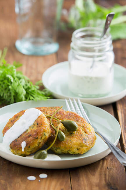 Smoked salmon cakes with capers and yoghurt dip - foto de stock