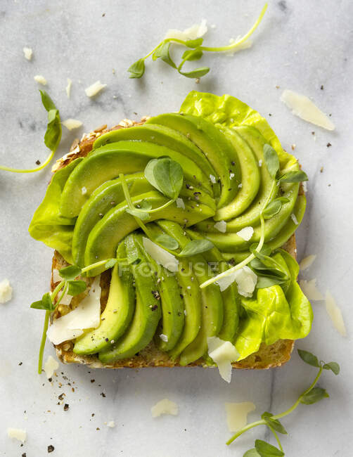 A slice of toast topped with avocado wedges (seen from above) — Stock Photo
