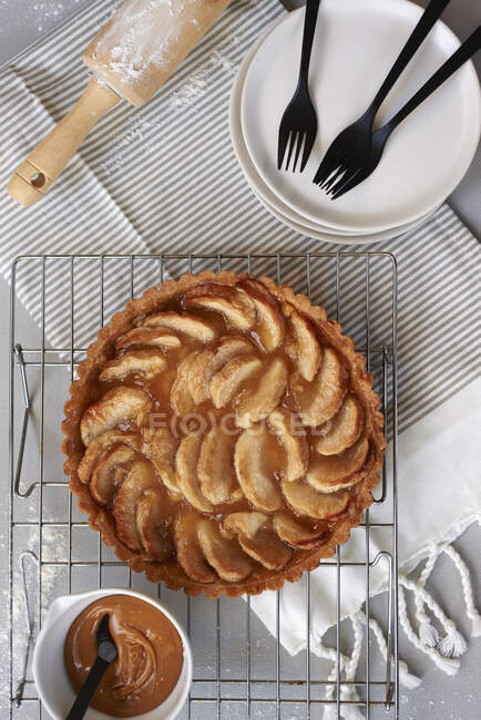 Apple pie with caramel sauce on wire rack — Stock Photo