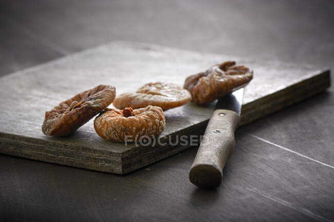 Fichi secchi su una tavola di legno con pelapatate — Foto stock