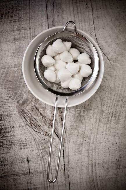 Mini mozzarella in a strainer — Stock Photo