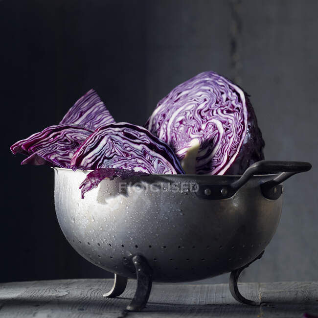 Red cabbage pieces with drops of water in an old metal colander — Stock Photo