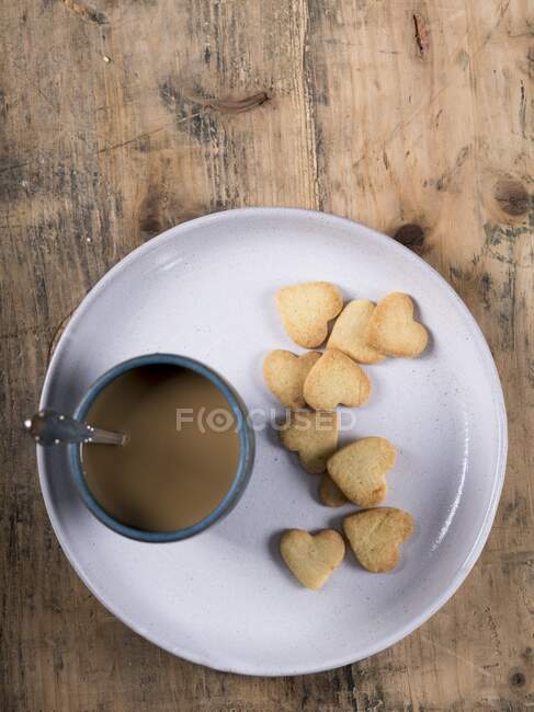 Galletas de pan corto y taza de café en el plato - foto de stock