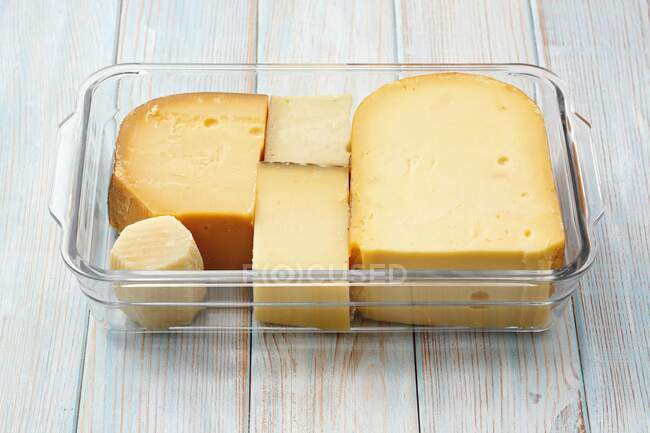 Различные сорта сыра: Гауда, Грате, Грейерзер, Пармезан в стеклянной тарелке — стоковое фото