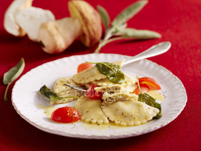 Porcini mushroom ravioli with sage butter and cherry tomatoes — Stock Photo