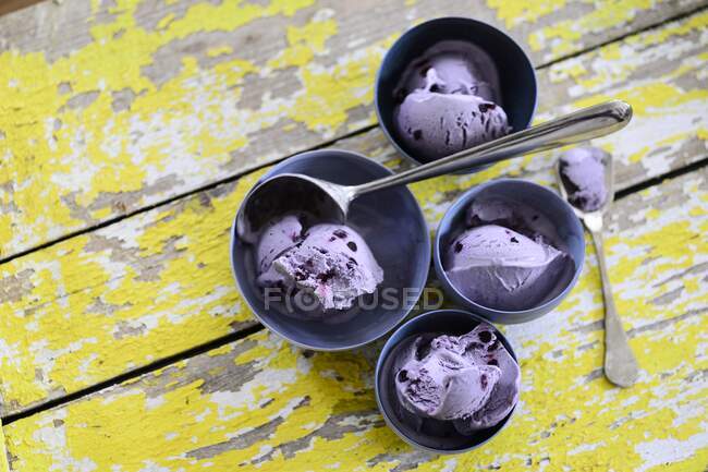 Várias tigelas de sorvete de mirtilo em um fundo de madeira — Fotografia de Stock