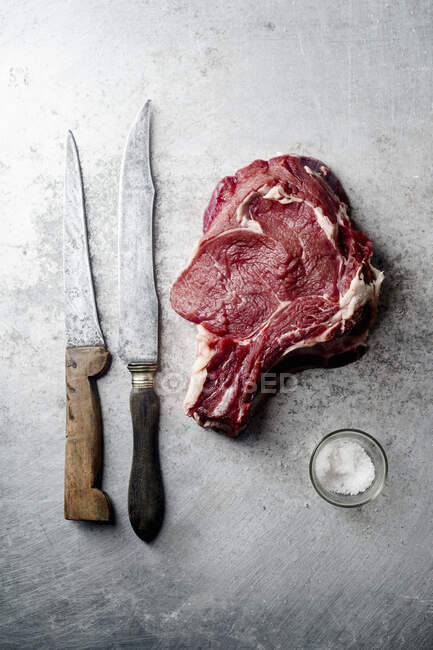 Bife cru com uma faca e uma pitada de sal — Fotografia de Stock