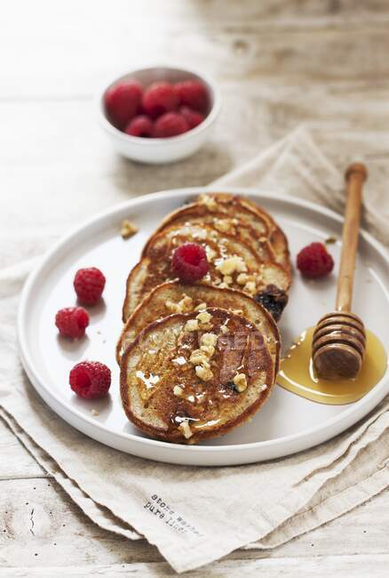Quark and buckwheat pancakes with blueberries, raspberries and a honey nut topping — Stock Photo
