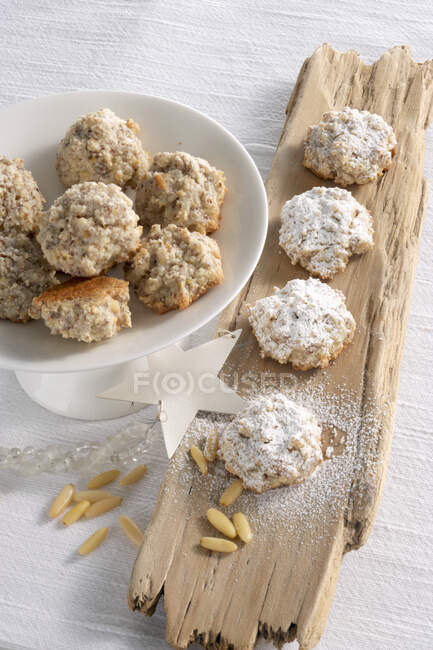 Biscuits aux noix de pin dans un bol et une planche en bois rustique — Photo de stock