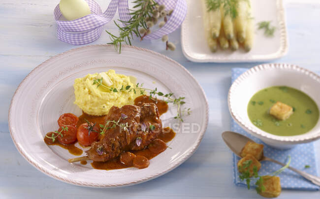 Um menu de Páscoa com sopa de cerefólio, pernas de coelho com purê de batatas e espargos — Fotografia de Stock