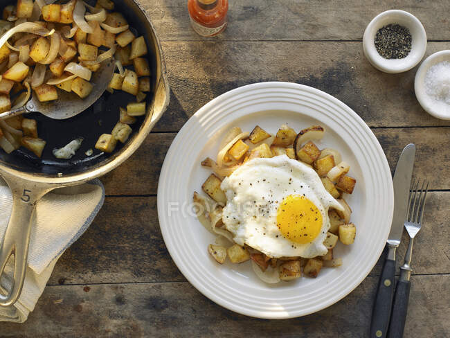Картопляний хеш зі смаженим яйцем на тарілці — стокове фото