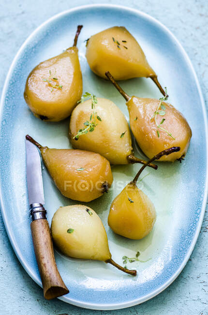 Poached pears on a blue plate — Stock Photo