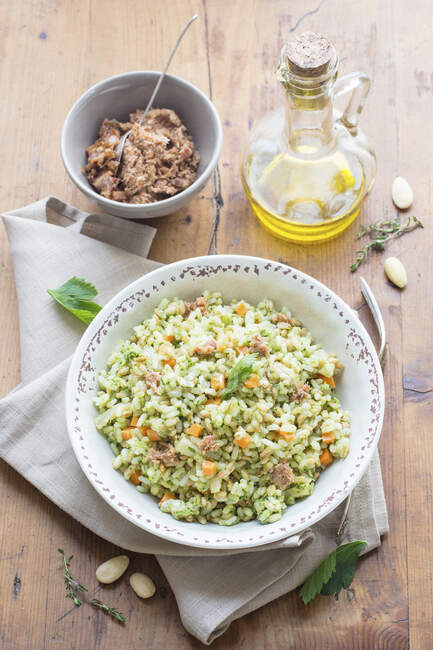 Rice Salad with Pesto and Vegetables, tuna in bowl and oil in bottle — Stock Photo