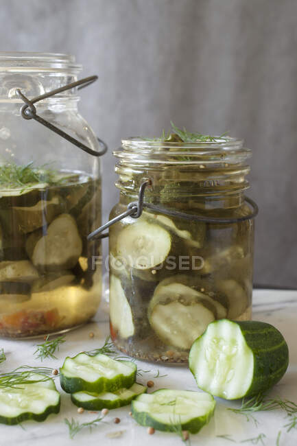 Pepinos em conserva fatiados marinando em frascos de vidro vintage — Fotografia de Stock