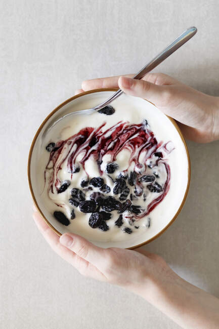 Hands holding bowl of Yoghurt with berries — Stock Photo