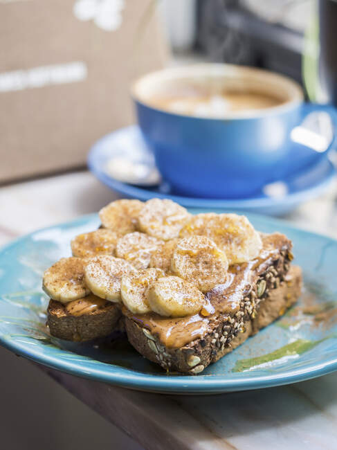 Whole grain sourdough toast wih organic almond butter, banana, honey and cinnamon — Stock Photo