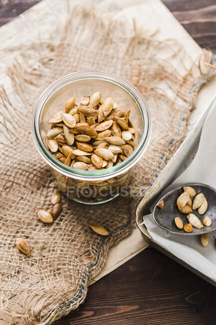 Un frasco de semillas de calabaza asadas - foto de stock
