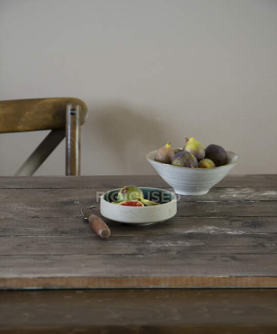 Figos frescos em tigelas em uma mesa de madeira — Fotografia de Stock