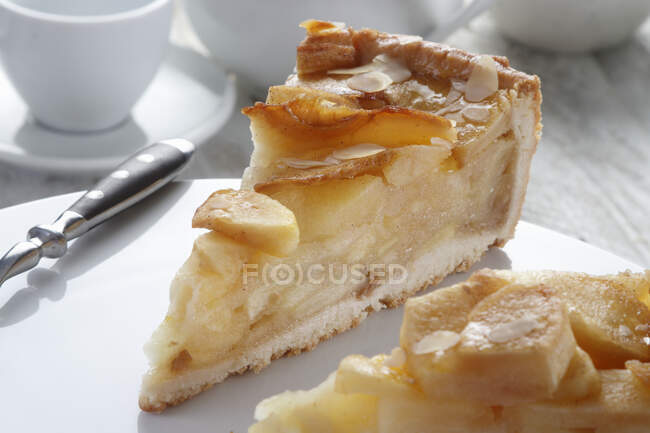 A piece of tart with apples and almond flakes — Stock Photo