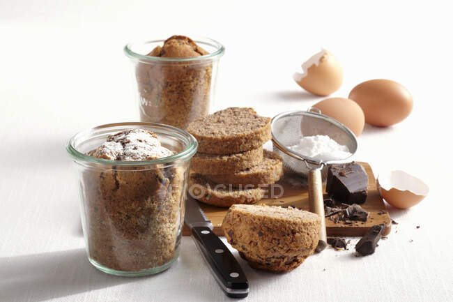 Mini pasteles de chocolate horneados en frascos con ingredientes - foto de stock
