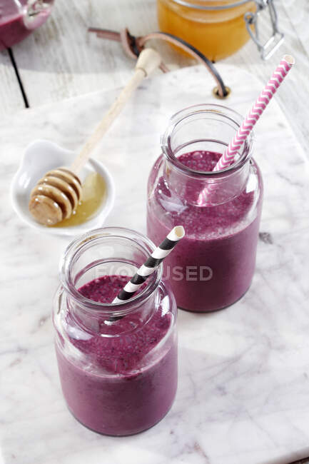 Blueberry smoothies in glass jars — Stock Photo