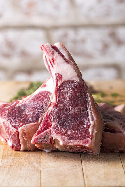 Raw beef chops on a wooden table — Stock Photo
