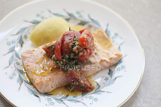Salmone con salsa verde e guarnizione di pomodoro — Foto stock