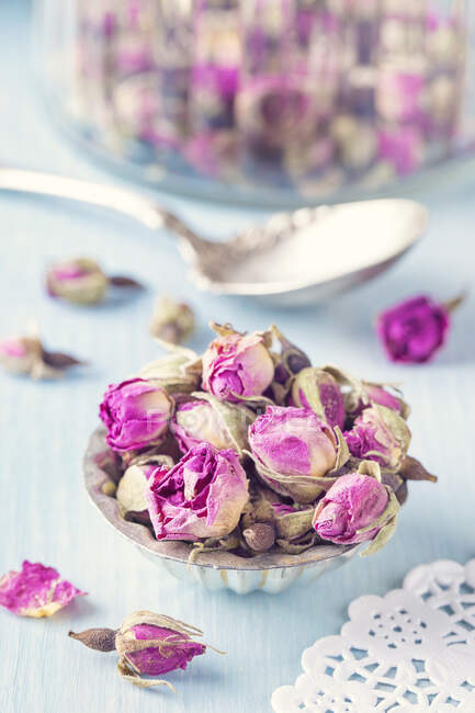 Dried rosebuds for tea in an old muffin tin — Stock Photo
