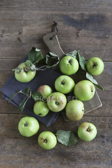 An arrangement of green organic apples on a rustic wooden table — Stock Photo