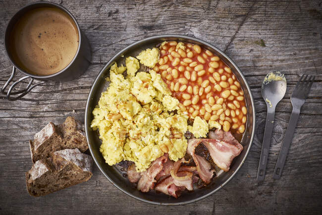 Desayuno con huevos revueltos, frijoles al horno y tocino - foto de stock